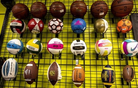 A shelf of different balls at a Play It Again Sports franchise